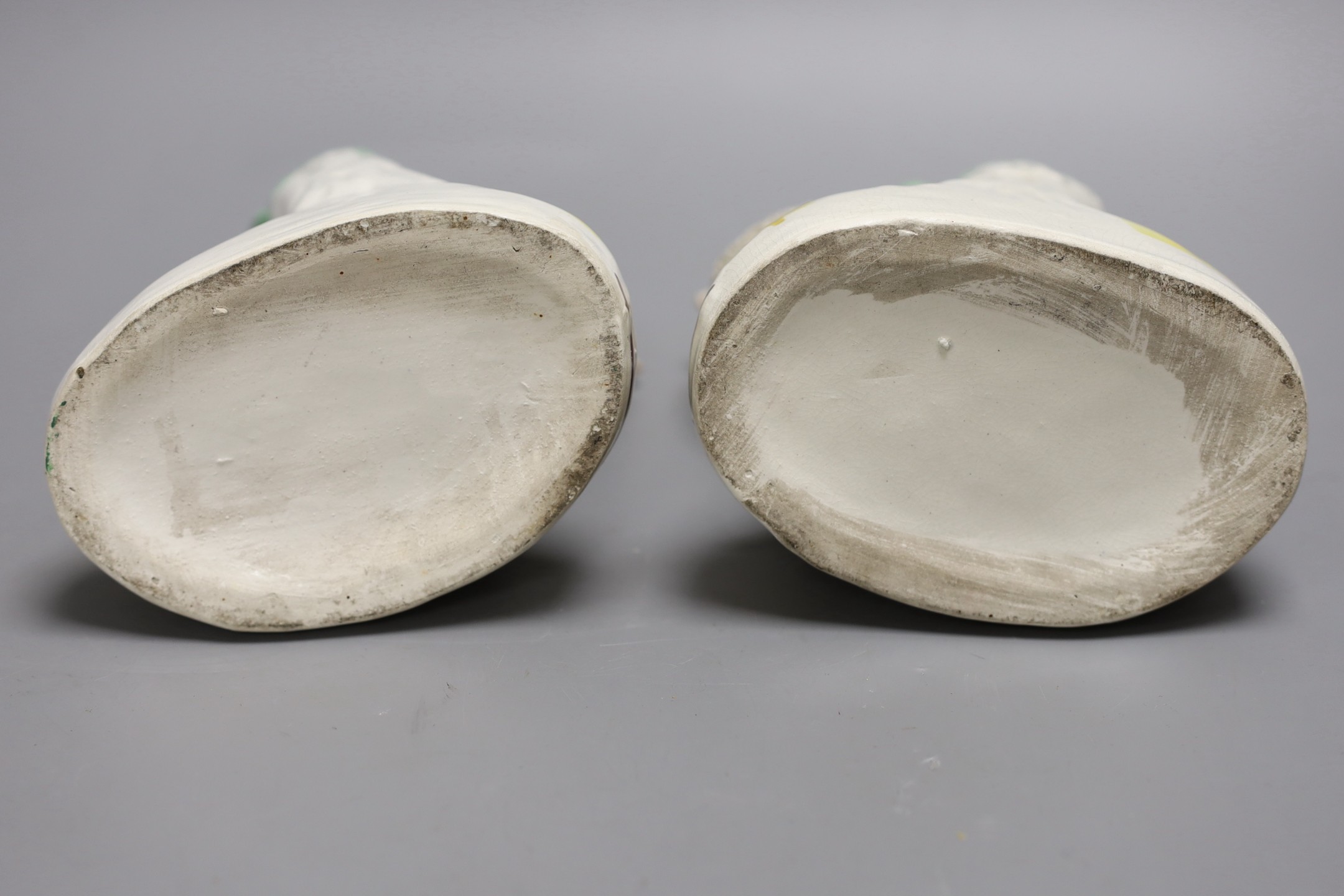 A pair of Staffordshire sheep spill vases, 19 cm high, a similar cow group and a recumbent man and dog